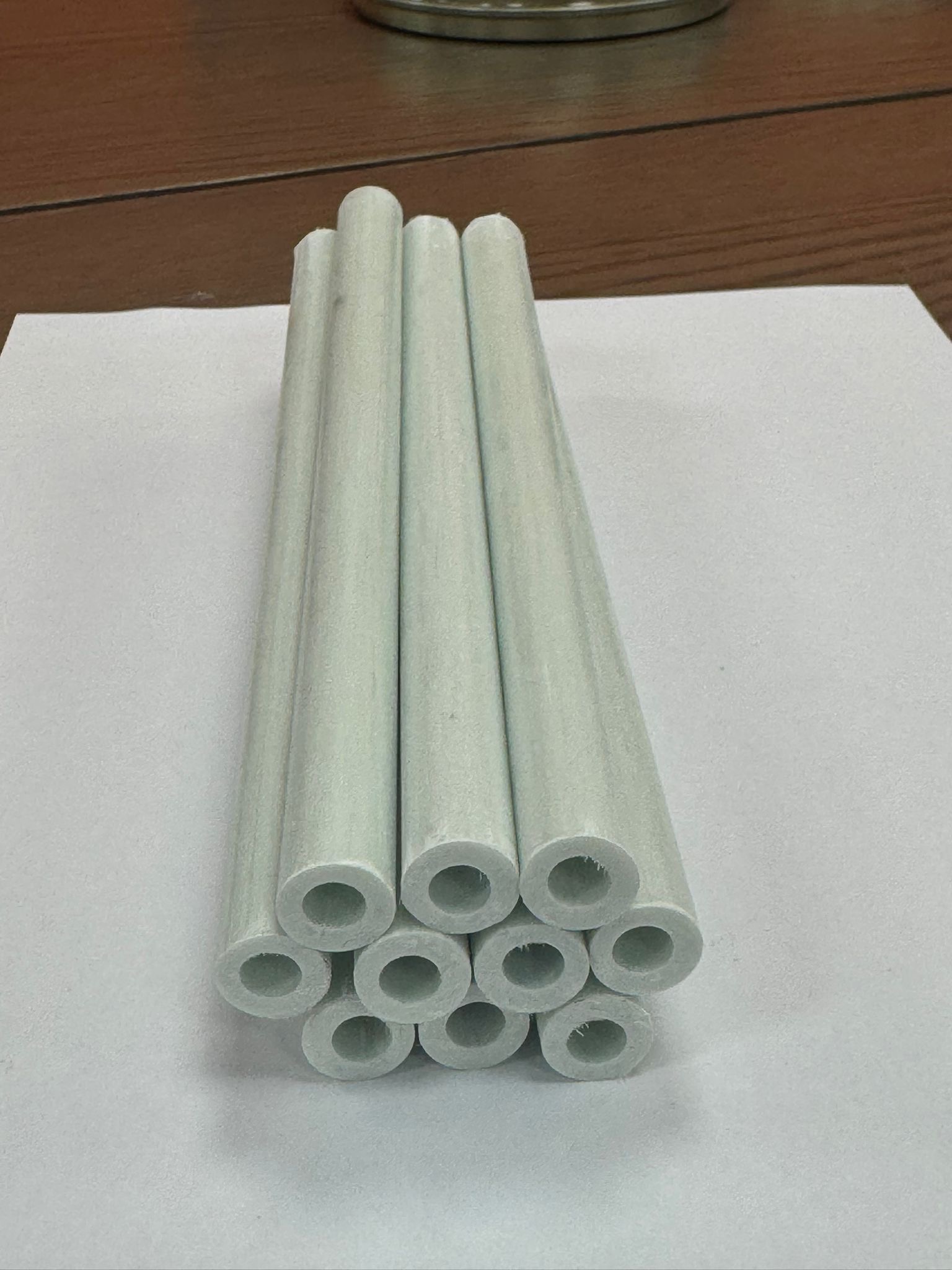 Stacked thermally isolated compression sleeves used to maintain load transfer while reducing heat loss through structural fixings