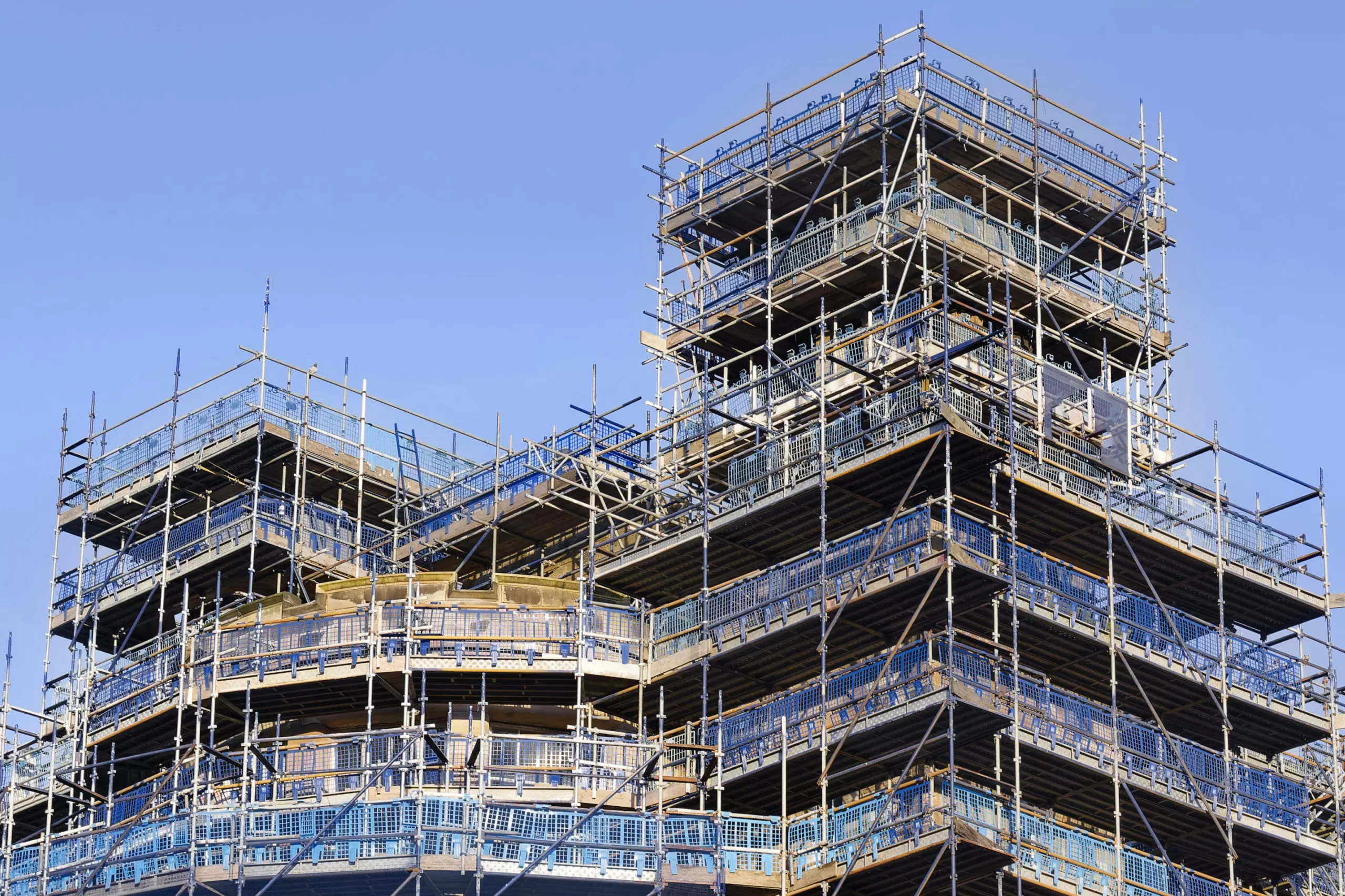 Multi-level scaffolding structure surrounding a high-rise building under construction